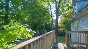 A wooden deck leading to a house with a visible window and a tree-lined yard. - Walk to Sorrento Town Dock: Pet-friendly Apartment (Sorrento)