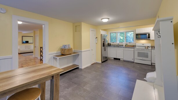 A modern kitchen with white cabinets, a stainless steel refrigerator, and a microwave. - Walk to Sorrento Town Dock: Pet-friendly Apartment (Sorrento)