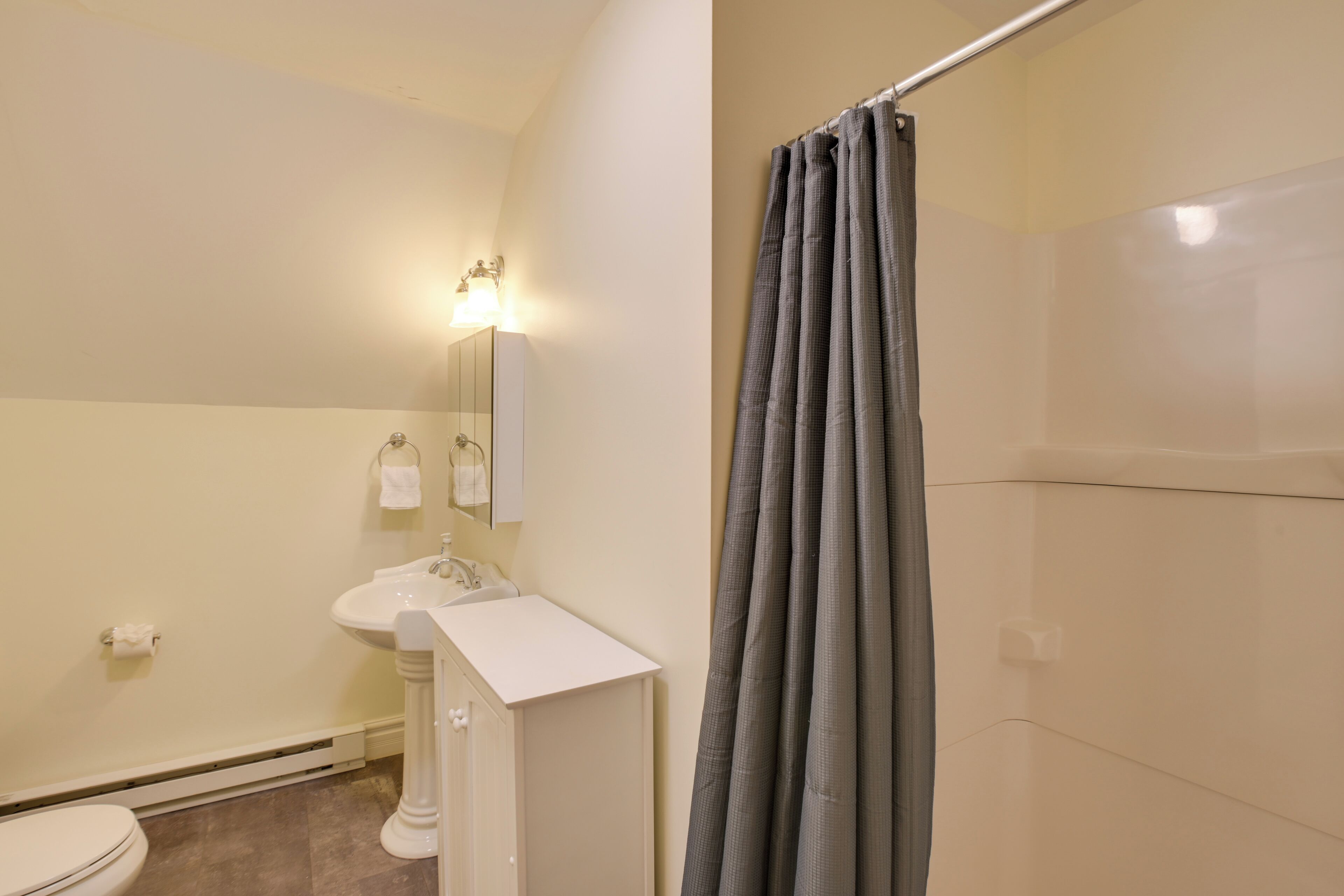 A bathroom with a toilet, sink, and mirror.