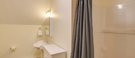 A bathroom with a toilet, sink, and mirror.