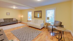 A living room with a grey sectional sofa, a white sofa, a grey rug, and a wooden coffee table. - Walk to Sorrento Town Dock: Pet-friendly Apartment (Sorrento)
