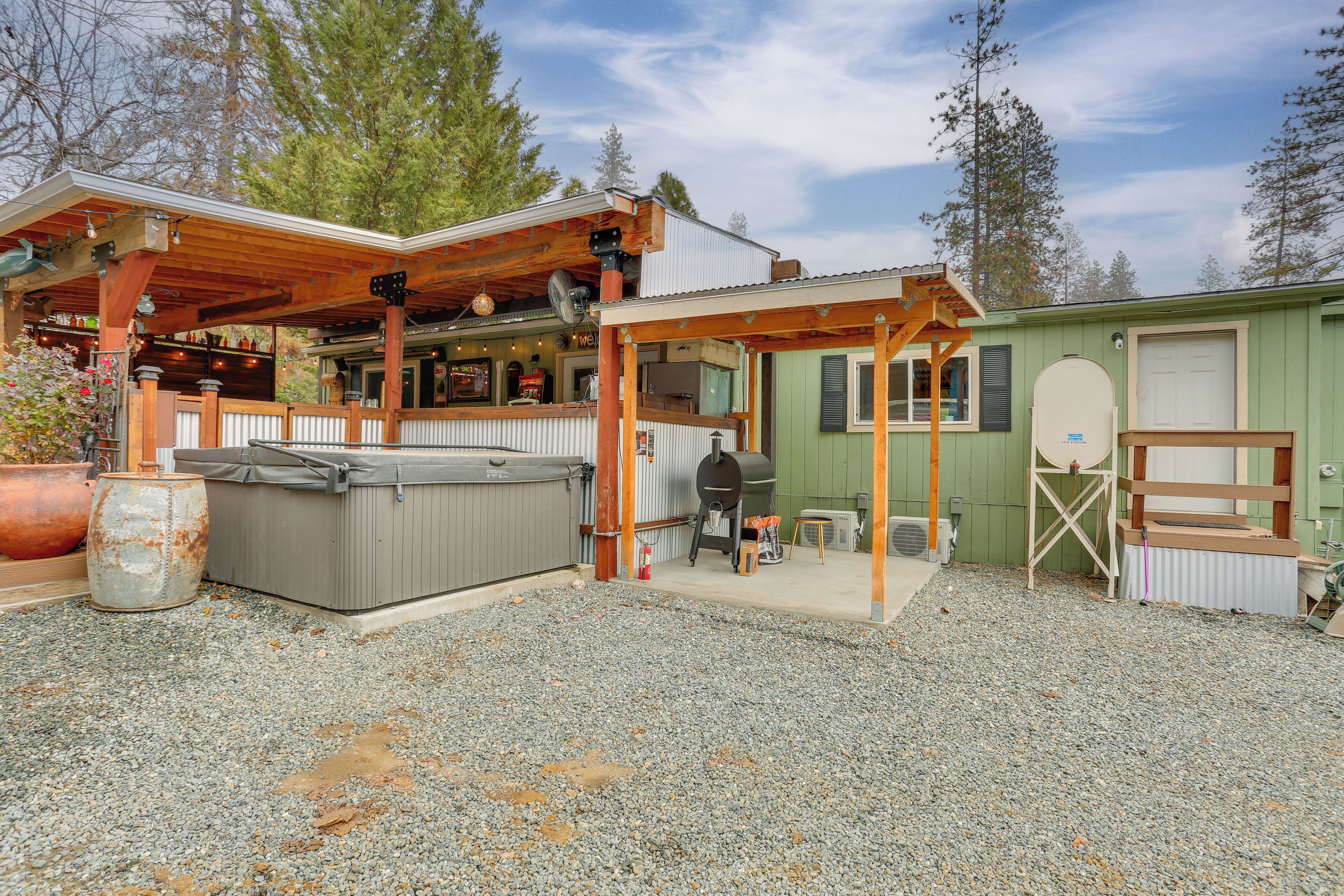 Un chalet rustique doté d’un patio couvert, d’un bain à remous et d’un petit espace de détente extérieur.