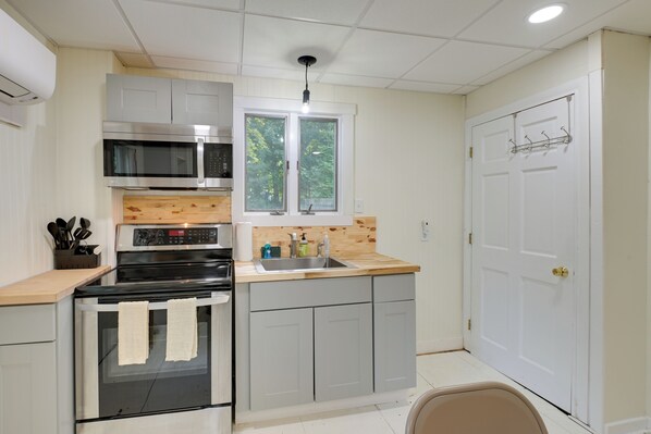 A compact kitchen with a microwave, oven, and wooden countertop. - Walk to Harbor: Pet-friendly Apt in Sorrento! (Sorrento)