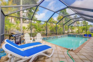 A covered swimming pool with lounge chairs and a grill area. - Fort Myers Vacation Rental w/ Lanai & Private Pool (Fort Myers)