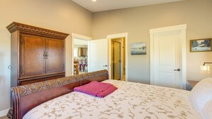 Una camera da letto con un letto grande, un armadio in legno e una porta che dà su un'altra stanza.