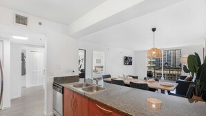 A modern kitchen with granite countertops, a dishwasher, and wooden cabinets. - Modern 1BR | Free Parking | Pool | Gym (Brickell)