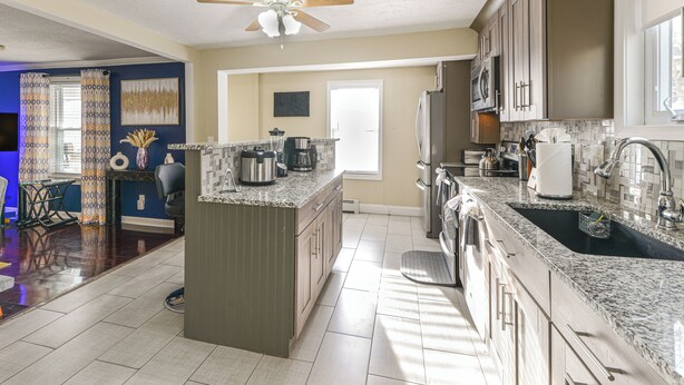 A modern kitchen with granite countertops, stainless steel appliances, and a large island. - Home Near Skiing & Downtown Worcester (Worcester)
