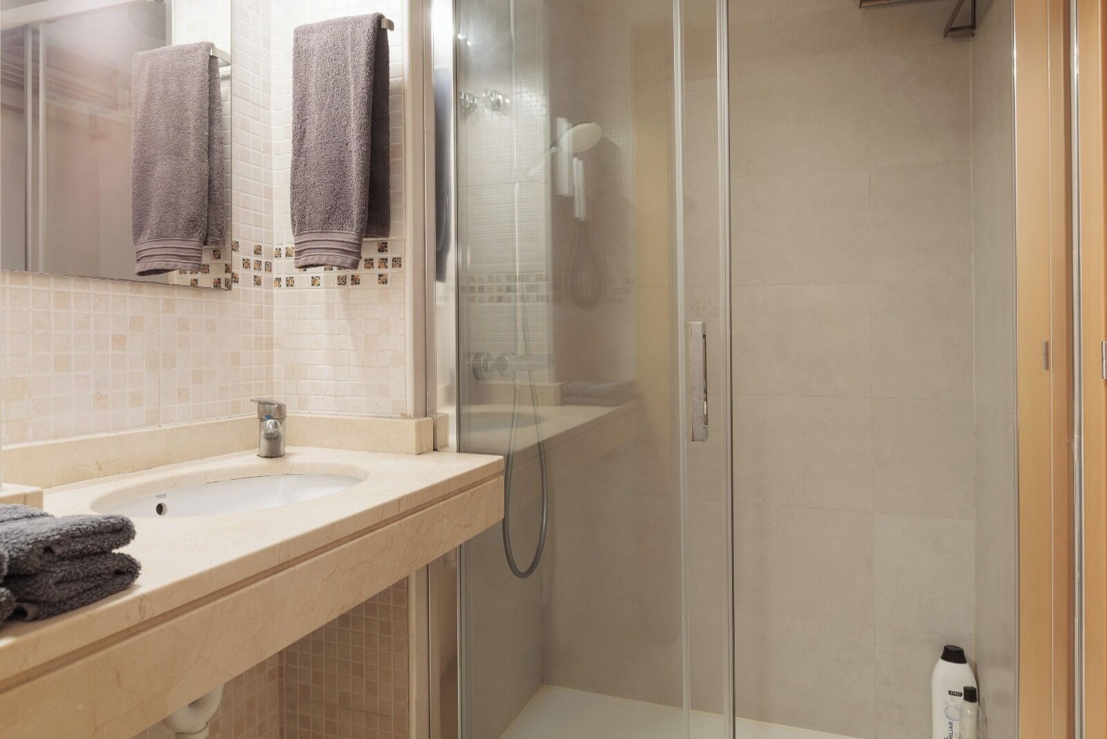 Un bagno con lavandino, specchio e doccia.