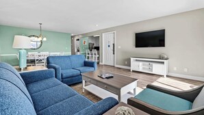 Uma sala de estar moderna com sofá, mesa de centro e televisão.