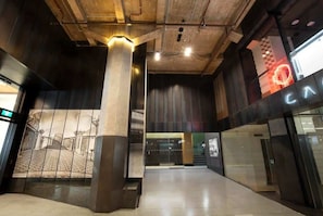 Ein modernes Interieur mit hohen Decken, Betonsäulen und einer Glasfassade.