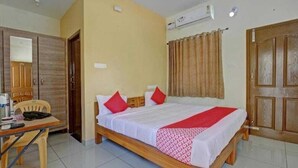 A bedroom with a bed, a desk, and a chair. - Sethu Residency (Thindukkal)