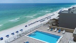 A rooftop pool with a view of the beach and ocean.