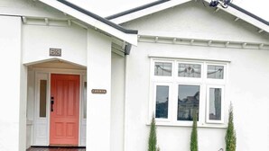 Un bâtiment blanc avec une porte rouge et une enseigne portant le numéro « 63 ».