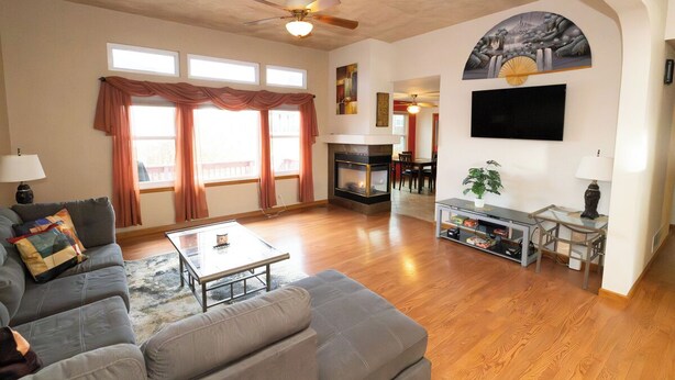 A living room with a sofa, coffee table, fireplace, TV, and a ceiling fan. - Tuscan Hills Hideaway - 6 Bedrooms, 14 beds, Up to 25 people (Westminster)