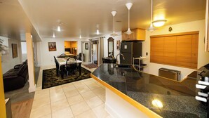 A modern kitchen with a granite countertop, white cabinets, and a wooden door. - Tuscan Hills Hideaway - 6 Bedrooms, 14 beds, Up to 25 people (Westminster)