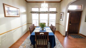 A dining room with a rectangular table, six chairs, a chandelier, and large windows. - Tuscan Hills Hideaway - 6 Bedrooms, 14 beds, Up to 25 people (Westminster)
