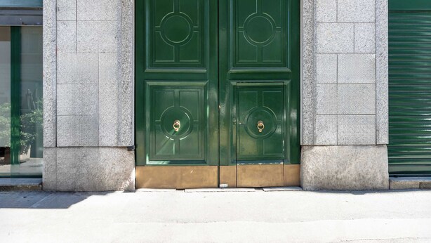 A green double door with a circular design, set in a stone building facade. - Casa Melzo, with garage near Porta Venezia (Milano)