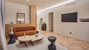 Un salon moderne comprenant un canapé, une table basse et deux petites tables d’appoint.