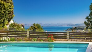 Ein Schwimmbad mit Blick auf das Meer und die Berge.