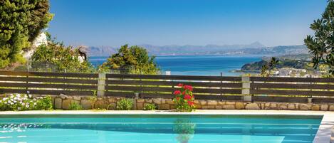 Alberca al aire libre, sombrillas en la alberca y camastros