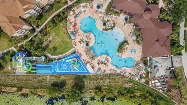 Vue aérienne d’un complexe hôtelier doté de plusieurs piscines, d’un parc aquatique et de divers espaces de détente en plein air.
