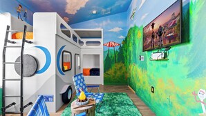 Une chambre avec un lit superposé, un téléviseur fixé au mur et une fresque représentant un paysage de parc.