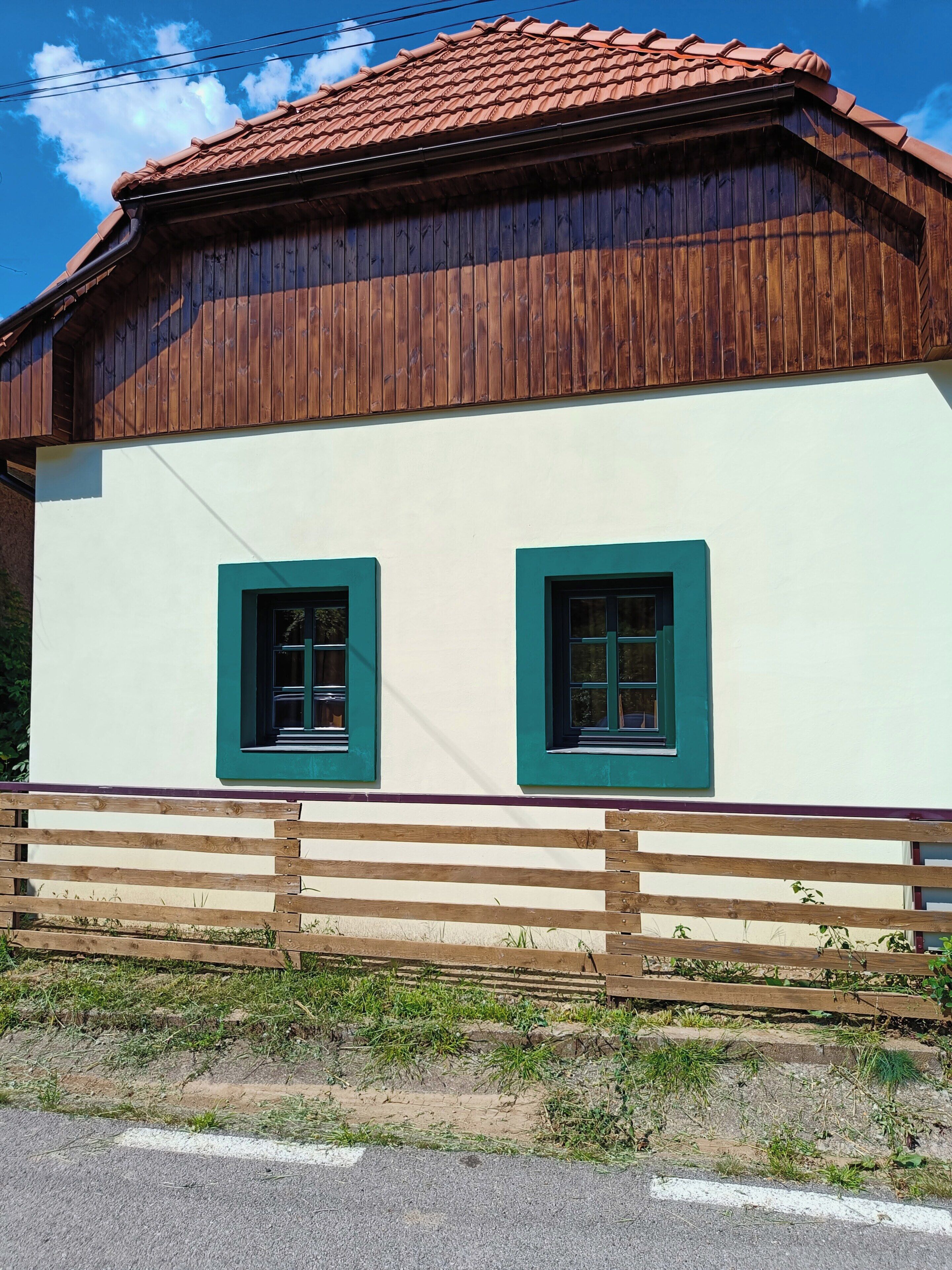A two-story building with a white facade and wooden trim around the windows.