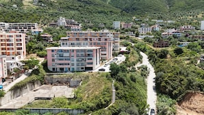 Un quartier résidentiel composé d’immeubles d’habitation à plusieurs étages, d’une route asphaltée et entouré de verdure.