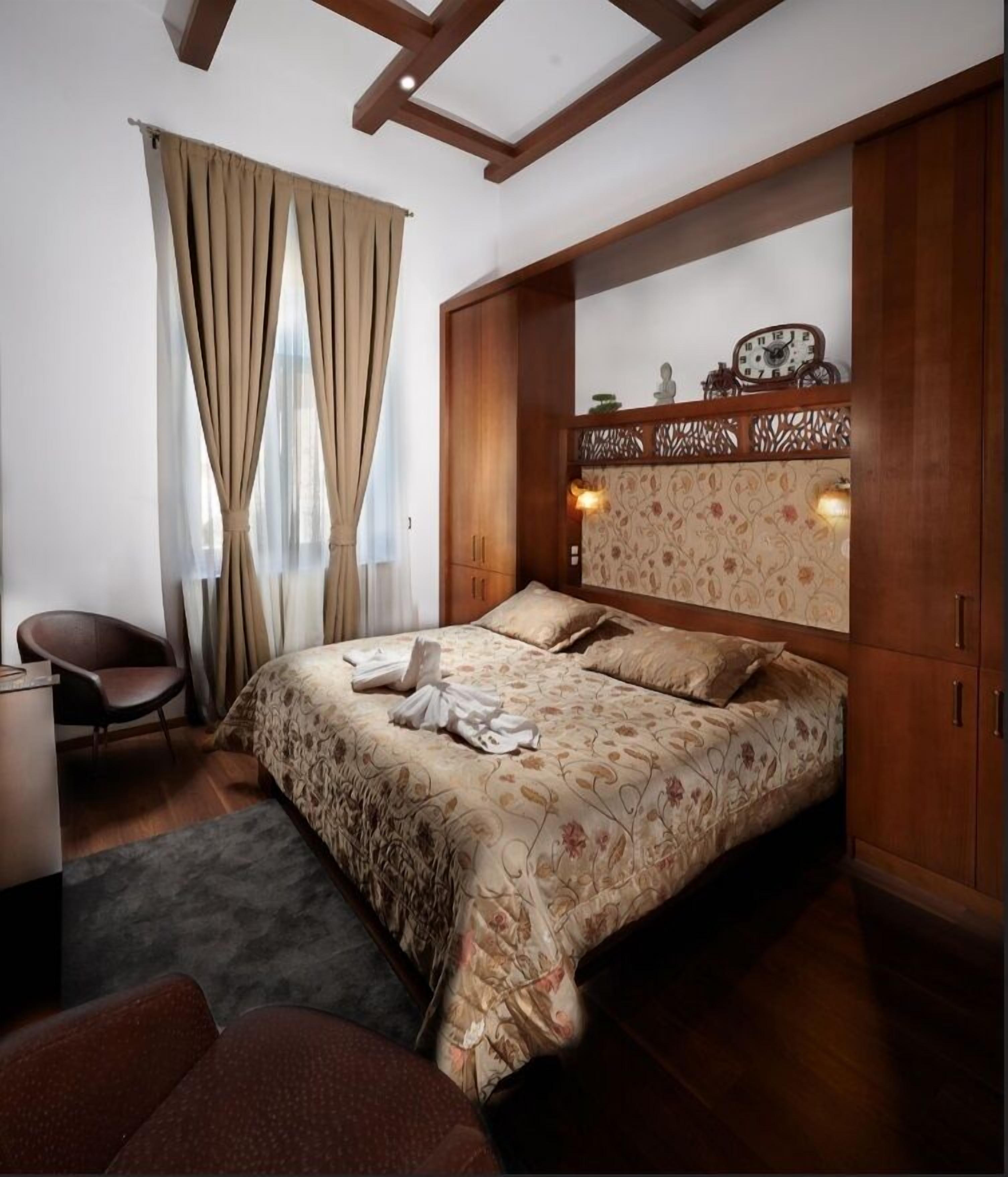 Ein Schlafzimmer mit Bett, Stuhl, Schreibtisch und Kleiderschrank.