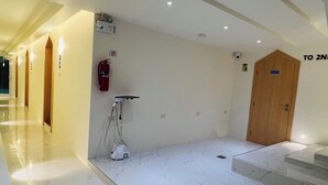 A hotel lobby with a marble floor, a fire extinguisher, a vacuum cleaner, and a wooden door labeled "TO 2ND". - Minitel at hatyai (Hat Yai)