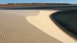 A desert landscape with sand dunes and a distant quarry. - HOTEL PLAYA DAKHLA (Dakhla)