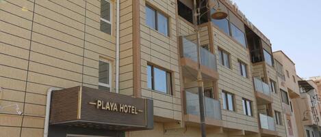 A multi-story hotel with a sign reading "PLAYA HOTEL".