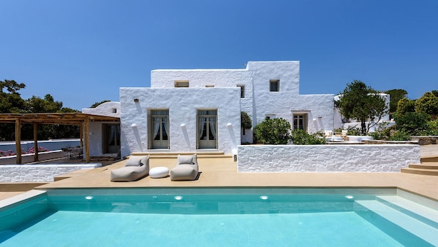 A modern white building with a pool, outdoor seating, and a pergola. - Villa Vinea Paros (Paros)