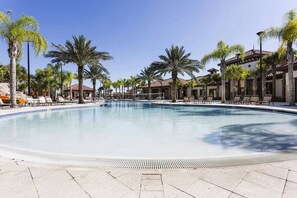 A large outdoor swimming pool with lounge chairs and palm trees. - Solterra 5BR with Private Pool Near Disney (Davenport)