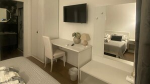 A bedroom with a bed, a desk, a chair, a TV, a mirror, and a wardrobe. - Charming 2-bedroom house in lovely Roma with AC, WiFi (Roma)