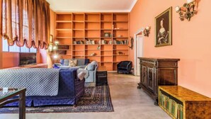 A cozy room with a large bookshelf, a sofa, and a fireplace. - Elegant Loft in the Heart of Milan – Spacious and Stylish
 (Milano)