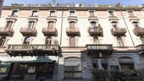 A building with multiple balconies, a closed entrance, and signs for 'Pizzeria' and 'Da Giuliano'. - Elegant Loft in the Heart of Milan – Spacious and Stylish
 (Milano)