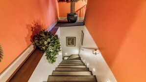 A staircase with a handrail, a potted plant, and a framed picture on the wall. - Elegant Loft in the Heart of Milan – Spacious and Stylish
 (Milano)