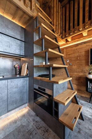 A modern kitchen with a built-in wooden staircase. - Chalet "Le Cocoonid" - Bain Nordique - Sauna (Ventron)