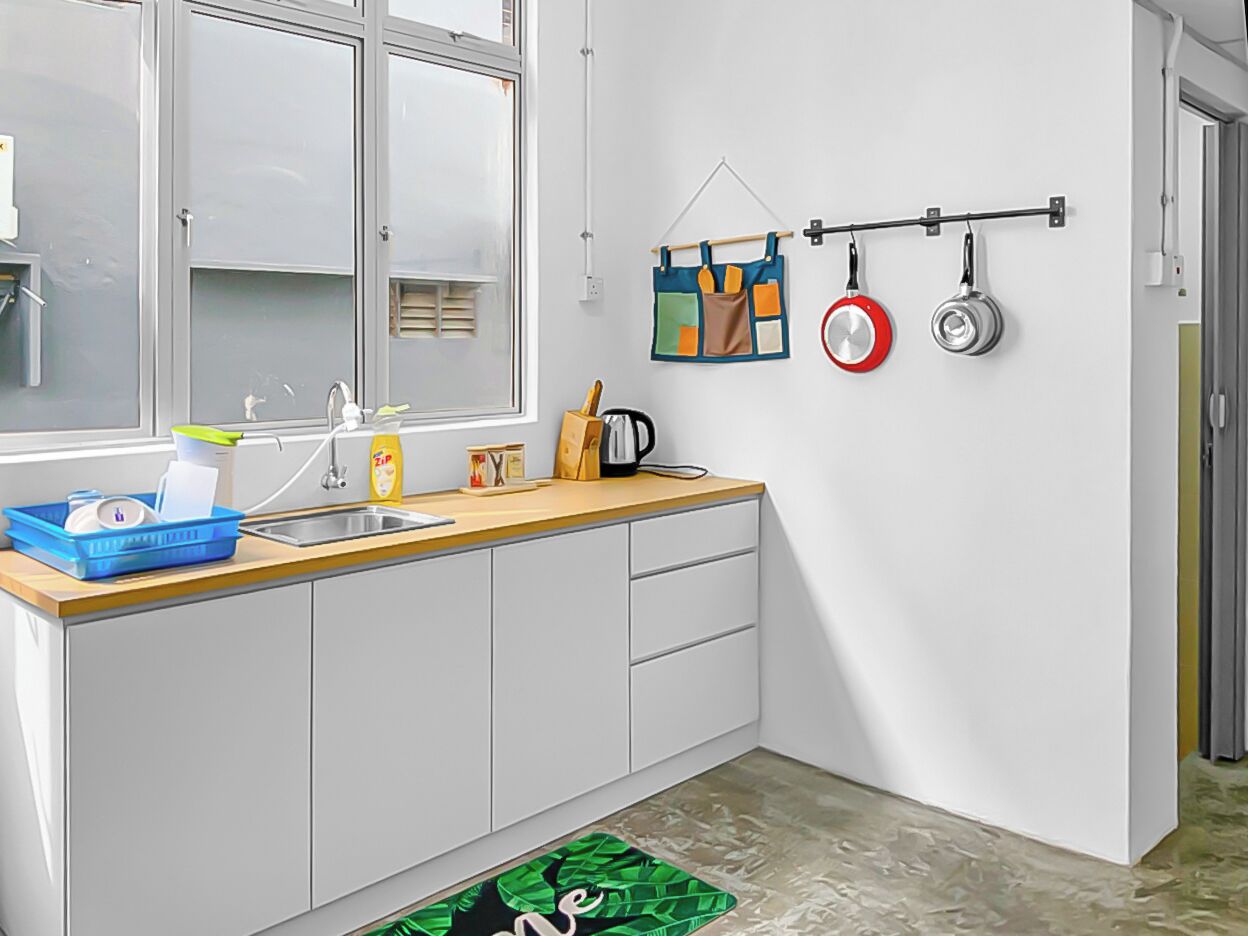 A modern kitchen with a window, a sink, a countertop, and a hanging pot rack.