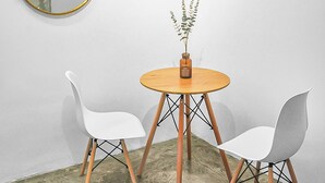 A small room with a round wooden table, two white chairs, a round mirror with a yellow frame, and a vase with a plant. - 3 Bedroom  (Batu Pahat)