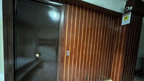 A closed door with a metal handle, a wooden panel wall with vertical slats, and a tiled floor with a geometric pattern. - Napoli Historic center Tribunali Duomo house (Napoli)