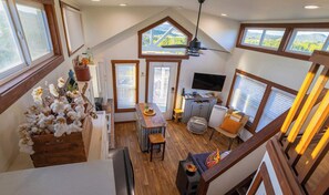 Une pièce de style loft comprenant un coin repas, un téléviseur et une kitchenette.