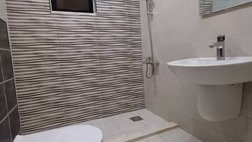 Separate bathtub and shower, towels, soap, toilet paper