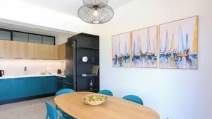 A modern kitchen with a dining area. - Dione Seaside Apartment with Sea View (Anissaras)