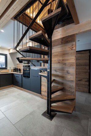 A modern kitchen with a built-in spiral staircase.
