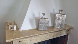 Ein Kaminbrett mit drei unterschiedlich großen Metallvasen.