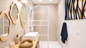 Un bagno moderno con un mobile lavabo, specchi, una doccia e un portasciugamani.