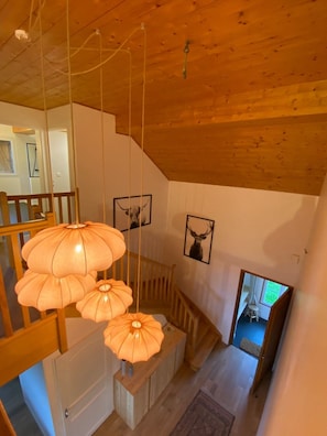 A wooden interior with a staircase, pendant lights, and framed animal pictures on the walls. - LE PERCHOIR - 14 guests - Lake view - Sauna, Gérardmer (Gérardmer)