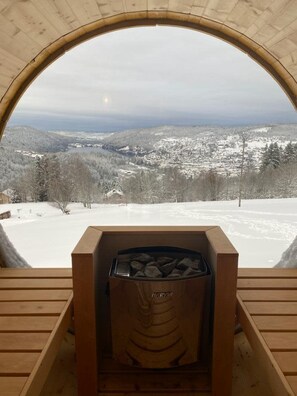 A wooden cabin with a fireplace, a wooden bench, and a view of a snowy landscape. - LE PERCHOIR - 14 guests - Lake view - Sauna, Gérardmer (Gérardmer)